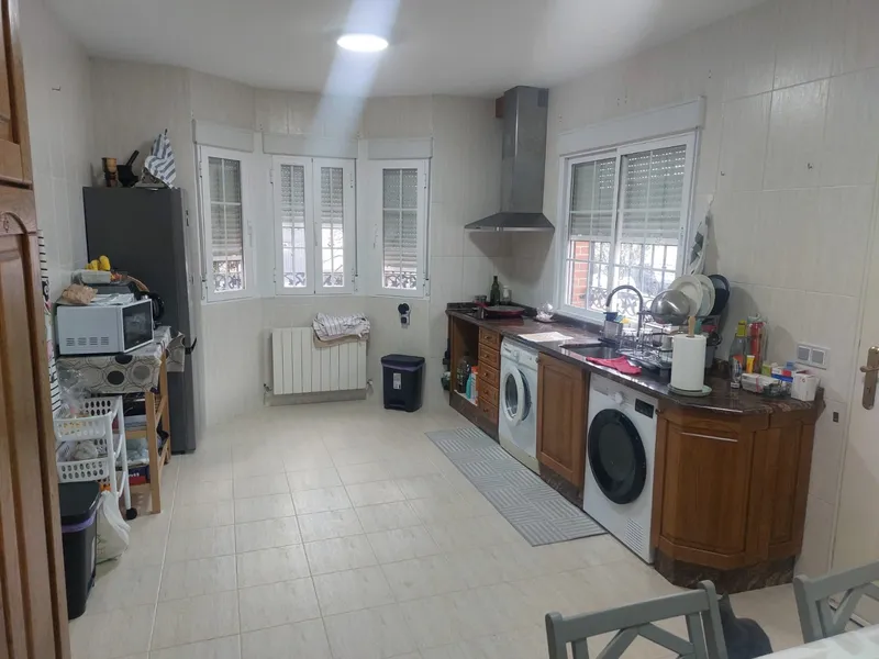 Cocina con suelo desgastado y revestimiento anticuado, antes de la reforma
